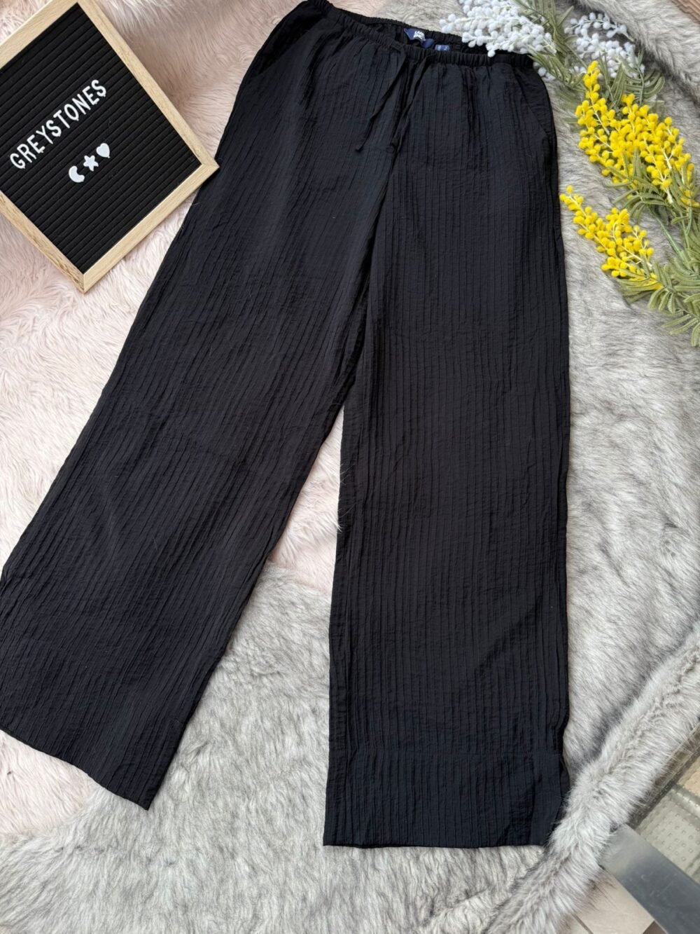 Crinkled cotton wide-leg pants in solid black with an elastic waistband and drawstring