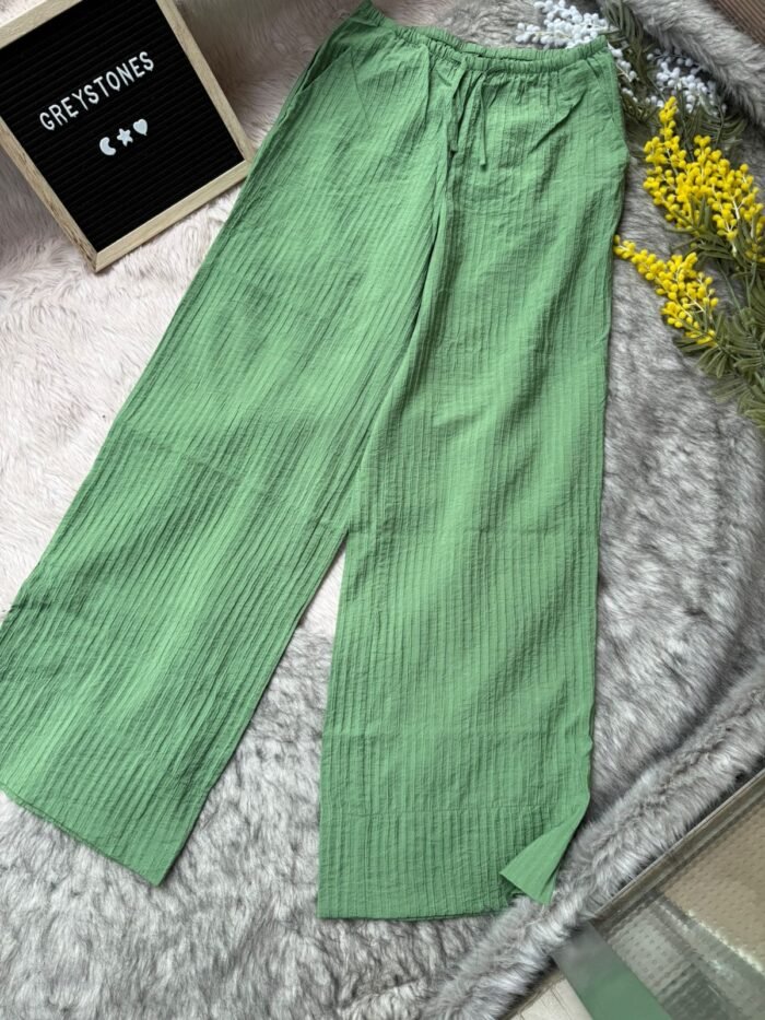 Light olive green crinkled cotton wide-leg pants with side pockets and drawstring waistband, styled for casual comfort.