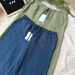 Flatlay of olive green and navy blue striped cotton wide-leg pants with drawstring waist