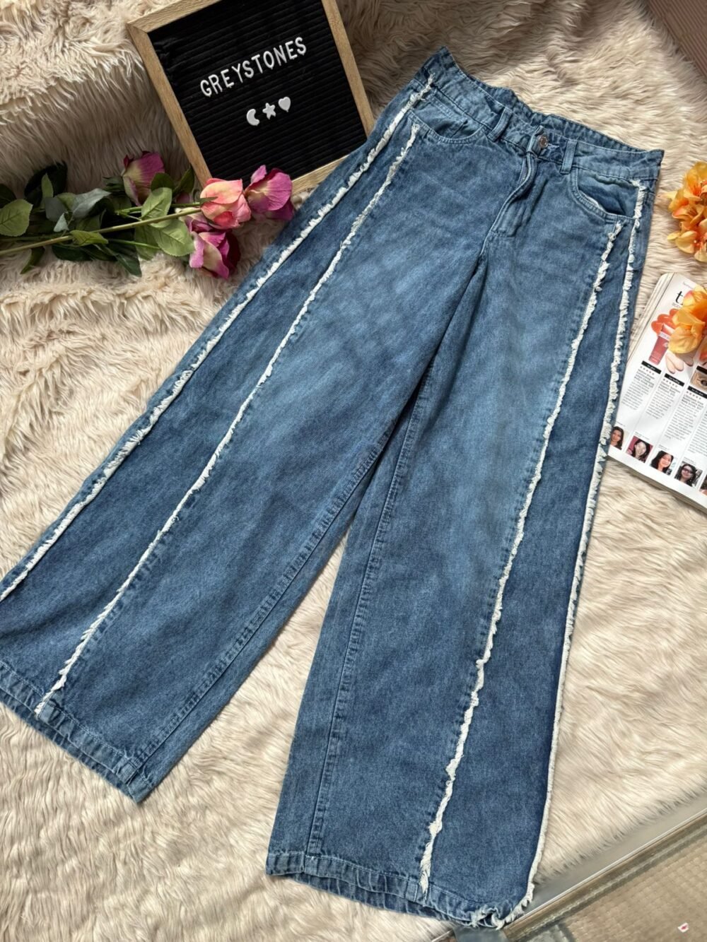 Vintage blue wide leg distressed jeans with raw seam detailing in a high-waist straight fit style