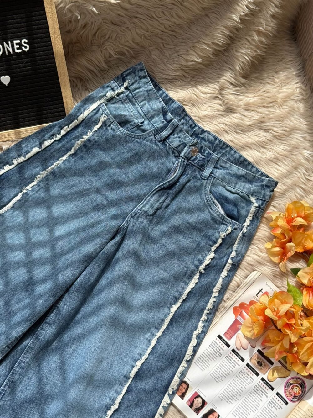 Vintage blue wide leg distressed jeans with raw seam detailing in a high-waist straight fit style