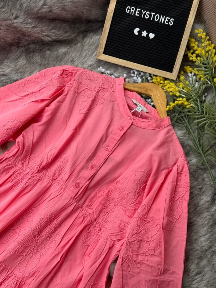 Coral pink embroidered cotton tunic dress with long sleeves, button-down front, and tiered flowy design,