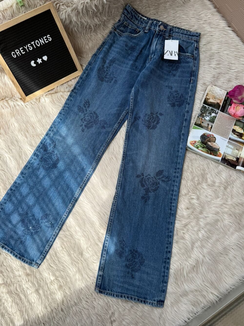 Dark blue denim jeans featuring subtle navy floral embroidery pattern