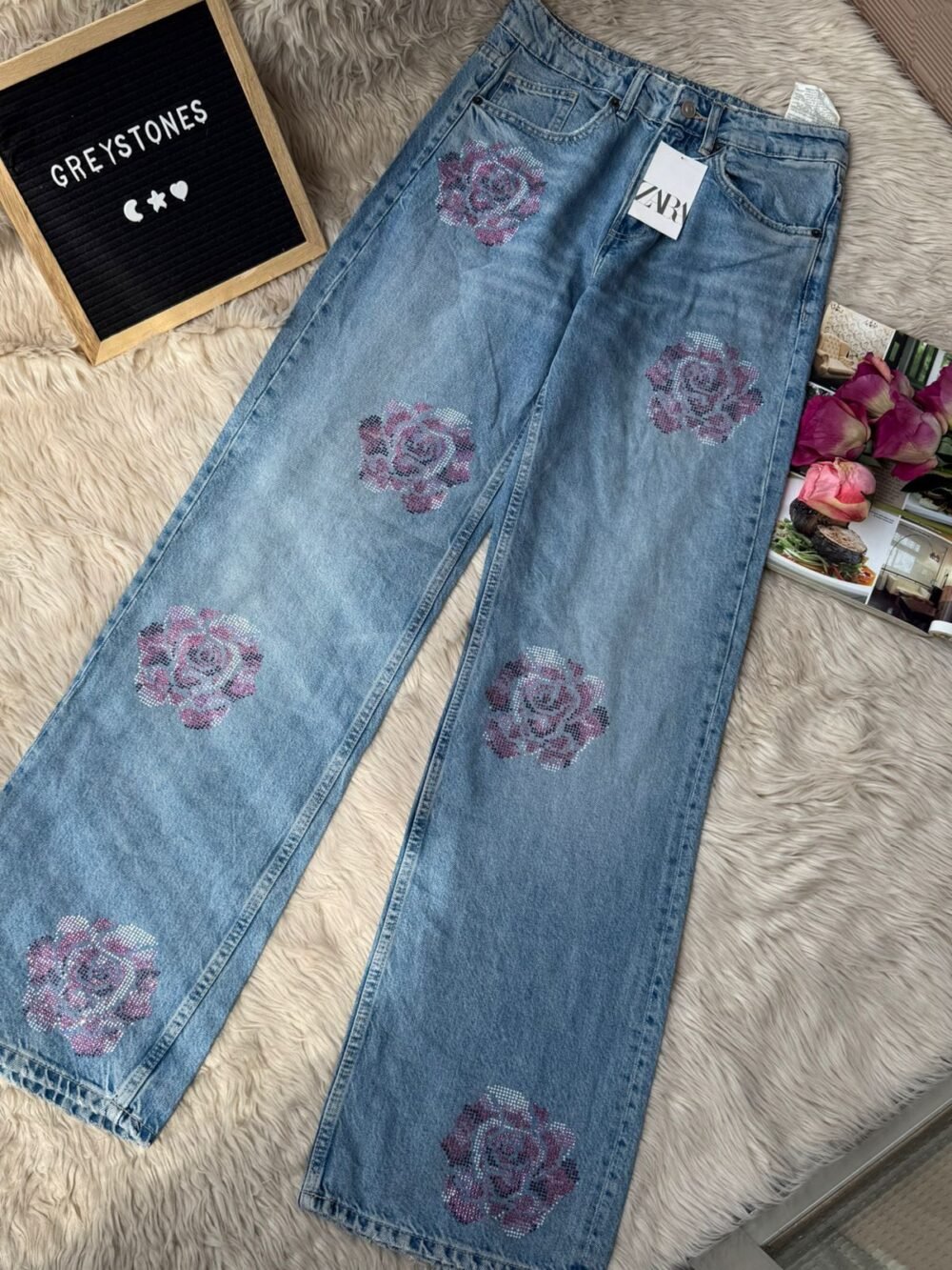 Light blue mid-waist denim jeans with pink floral embroidery on pockets