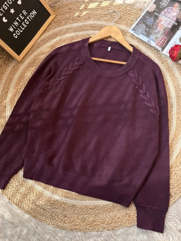 Maroon women’s knit sweater featuring an embossed leaf design near the neckline