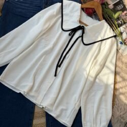 White blouse with wide black-trim collar and ribbon tie