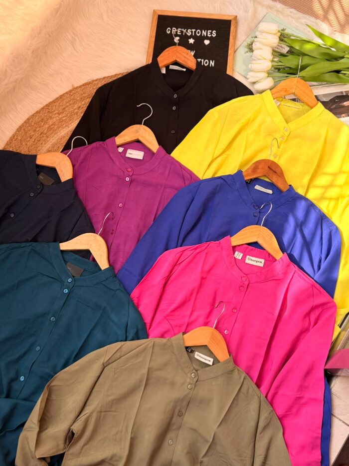 Assorted solid color women’s long tunic shirts with button-front design