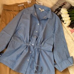 Blue and white striped cotton women’s shirt with adjustable drawstring waist paired with brown high-waist trousers