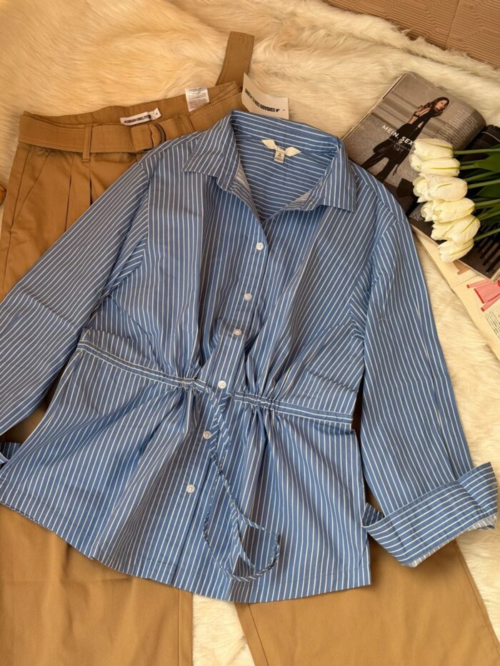 Blue and white striped cotton women’s shirt with adjustable drawstring waist paired with brown high-waist trousers