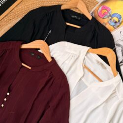 Women’s premium pinstripe blouse in maroon, black, and ivory white displayed on hangers, featuring mandarin collar and elegant casual design